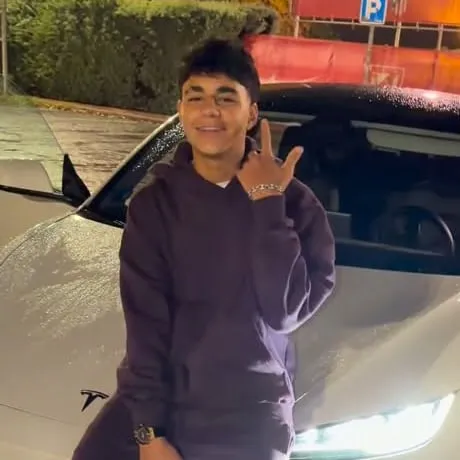 YOVNGBY junto a un carro blanco en el adelanto de "En Medallo"
